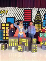 Principal and Assistant Principal in front of Super Heroes backdrop